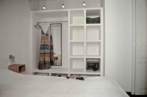 a white bedroom with a bed and a mirror at Barceloneta Suites Apartments Market in Barcelona