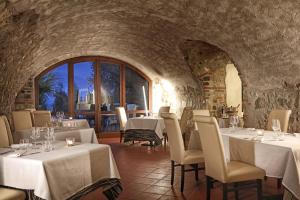 un restaurante con mesas y sillas blancas en una habitación en San Rocco Relais, en Soiano del Lago