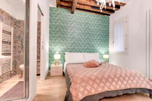 a bedroom with a bed and a green wall at Rialto Prestige - Campo S Maria Formosa by Wonderful Italy in Venice