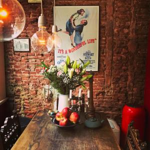 einen Holztisch mit einer Schale Obst und Blumen in der Unterkunft The Lastage Inn - Bed & Breakfast in Amsterdam