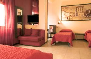 Habitación de hotel con cama, silla y TV. en Hotel Grazia Eboli, en Éboli