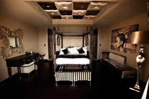 a bedroom with a bed and a table in it at Palala Boutique Game Lodge and Spa in Tom Burke