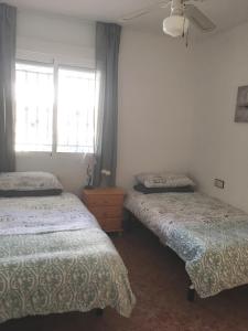 1 dormitorio con 2 camas y ventana en Casa Verano en Vistabella