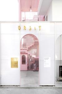 een deur naar een roze gebouw met een bord waarop staat terug bij Orbit - For foreigners only in Seoul