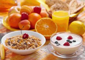 a table with a bowl of granola and a plate of fruit at Armenia Hostel in Yerevan