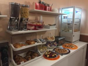 um balcão de cozinha com vários produtos de pastelaria e outros alimentos em Hotel Bogart 2 em Milão