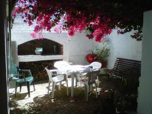 a table and chairs in a patio with a fireplace at Peak Village Lodge in Bloubergstrand +13 photos
