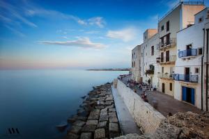 un groupe de bâtiments à côté d'une masse d'eau dans l'établissement Casa Jole, à Monopoli