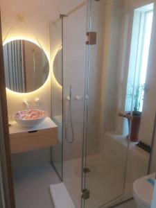 a bathroom with a shower, sink, and toilet at Ekies All Senses Resort in Vourvourou