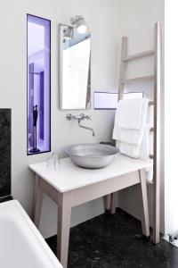 a bathroom with a sink and a mirror at Ekies All Senses Resort, a Member of Design Hotels in Vourvourou