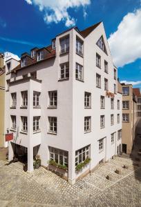 een groot wit gebouw met ramen aan een straat bij Hotel am Rathaus in Augsburg