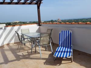 a table and chairs on a balcony with a view at Mazotos Panoramic Village in Mazotos