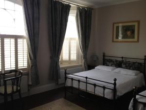 a bedroom with a bed and two windows at Balham Lodge in London
