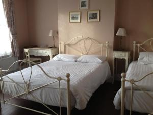 a bedroom with two beds and two tables and a window at Balham Lodge in London