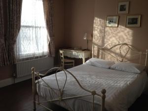 1 dormitorio con cama, escritorio y ventana en Balham Lodge en Londres