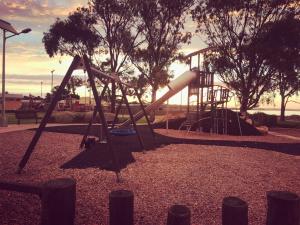 a playground with a slide in a park at Lake Albert Motel in Meningie