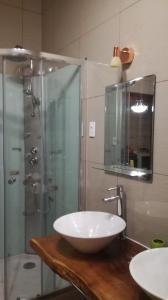 a bathroom with a sink and a glass shower at TIK'A WASI SUP in San Pedro de Atacama