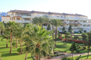 een groot gebouw met palmbomen ervoor bij Villa Romana Roquetas in Roquetas de Mar