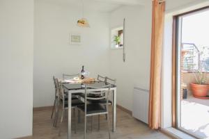 een eetkamer met een tafel en stoelen en een raam bij Pretty flat with terrace, air cond, free parking in Porto