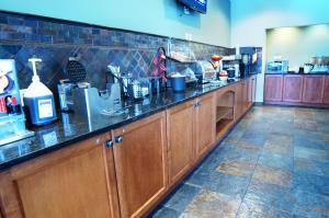 a kitchen with wooden cabinets and a counter top at Ramada Merritt in Merritt