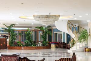 タシュケントにあるホテル ウズベキスタンの階段とシャンデリアのあるロビー