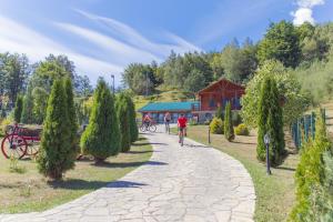 a person walking down a path in a park with trees at Hotel & Resort Gacka in Mojkovac