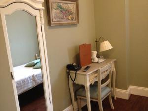 a room with a desk with a mirror and a bed at Balham Lodge in London
