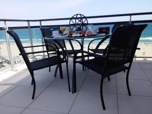 a table and chairs on a balcony with a view of the beach at Sunset Horizon Canet - Vue Panoramique Mer Montagne in Canet-en-Roussillon +38 photos
