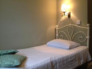 a bedroom with a white bed with a lamp on the wall at Balham Lodge in London