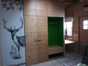 ein Bad mit einer Dusche und einem an der Wand gemalten Hirsch in der Unterkunft Albergo Riglarhaus in Sauris