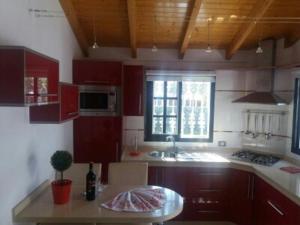 a kitchen with red cabinets and a table and a window at Casita Dayana - Costa del Silencio in Costa Del Silencio