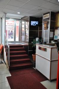 a staircase in a restaurant with a counter and a kitchen at Hekimoğlu Hotel in Erzurum