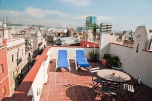 Un balcón con 2 sillas azules y una mesa. en Barceloneta Suites Apartments Beach, en Barcelona