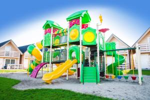a playground with a slide in a yard at Holiday Park & Resort Grzybowo in Grzybowo +39 photos