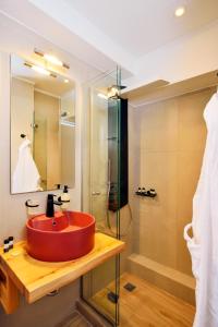 W łazience znajduje się czerwona umywalka i prysznic. w obiekcie Elia Beach w Chanii