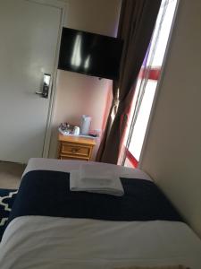 a bedroom with a bed with a television and a window at Trivelles Belforte Hotel in Sale