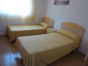 カンブリルスにあるapartamento Estelのベッド2台と窓が備わる客室です。