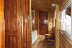 a hallway of a wooden cabin with a door and a chair at Casa Daya in Topliţa