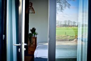 a door to a bedroom with a view of a bed at De Woeste Wieven op Erve Bonkert in Diepenheim
