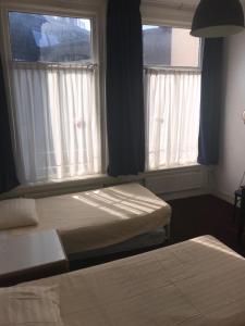 2 camas en una habitación con 2 ventanas en Hotel Galerij, en Ámsterdam