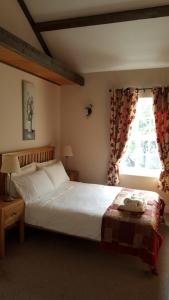 a bedroom with a large white bed and a window at The Oak at Dewlish in Dorchester