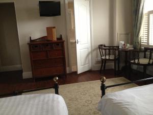 a bedroom with a bed and a dresser and a table at Balham Lodge in London