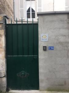 a green door on a building with a gate at Le Sumatra centre 400m gare wifi linge de pressing in Niort
