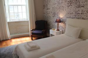 1 dormitorio con 1 cama, 1 silla y 1 ventana en Porto with History, en Oporto