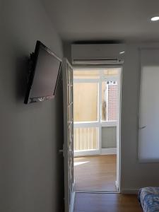 una puerta abierta a una habitación con ventana y TV en Hostal Montsant, en Salou