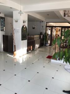 a living room with a white tiled floor at Hotel boutique Garden Resort by Brancoveanu in Moieciu de Jos
