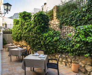 un restaurante con mesas y sillas frente a una pared en Hotel Zuhayra, en Zuheros