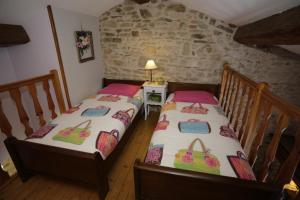 Habitación con 2 camas individuales y pared de piedra. en Carpe Diem en Soucieu-en-Jarrest