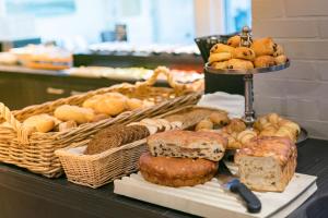 a table with different types of bread and pastries at Hotel Zeerust Texel in De Koog