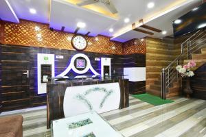 a lobby with a clock on the wall and a table at Surbhi Guest House in Dharamshala